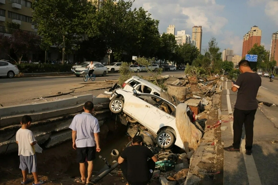 △郑州暴雨过后，被水冲到路边的汽车（图|视觉中国）